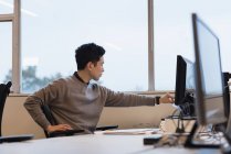 Uomo d'affari che lavora su PC desktop in ufficio — Foto stock