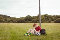 Junge Fußballerin entspannt auf dem Feld — Stockfoto