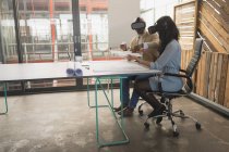 Чоловічі та жіночі керівники використовують гарнітуру віртуальної реальності в офісі — стокове фото