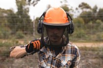 Close-up of lumberjack in hardhat at forest — Stock Photo