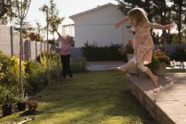 Menina brincando no jardim em um dia ensolarado — Fotografia de Stock
