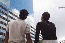 Rear view of couple standing in city street — Stock Photo