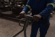 Mid section of blacksmith working in workshop — Stock Photo