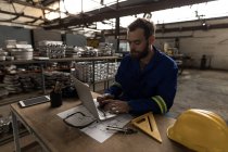 Schmied mit Laptop in Werkstatt — Stockfoto