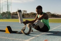 Disabled athlete wearing prosthetic leg on a running track — Stock Photo