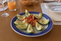 Крупный план нарезанного авокадо и перца в тарелке — стоковое фото