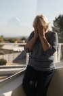 Занепокоєна жінка прикриває обличчя на терасі — стокове фото