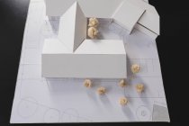 Plan rapproché du modèle de maison avec papier froissé sur le bureau — Photo de stock