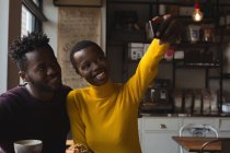 Счастливая пара делает селфи в кафе — стоковое фото