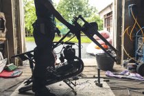 Baixa seção de mecânica feminina reparação de moto na garagem — Fotografia de Stock