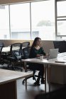 Концентрована бізнес-леді працює на ноутбуці в офісі — стокове фото