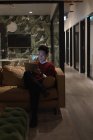 Концентрований бізнесмен сидить на дивані і використовує цифровий планшет в офісі — стокове фото