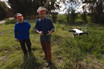 Dos leñadores operando dron en el bosque - foto de stock