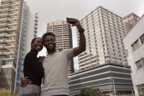 Happy couple taking selfie on city street — Stock Photo