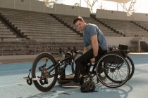 Athlète handicapé masculin avec fauteuil roulant sur une piste de course — Photo de stock