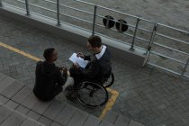 Deux athlètes handicapés discutent sur le presse-papiers sur le site sportif — Photo de stock