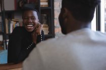 Счастливая женщина смотрит на мужчину в кафе — стоковое фото
