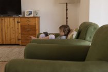 Girl using digital tablet in living room at home — Stock Photo