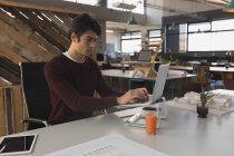 Esecutivo maschile che lavora su laptop in ufficio — Foto stock