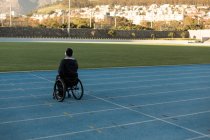Вид ззаду спортсмена-інваліда, який слухає музику на навушниках — стокове фото