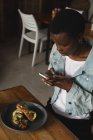 Жінка фотографує їжу в кафе — стокове фото