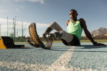 Tired disabled athlete relaxing on a running track — Stock Photo