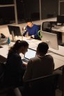Три бизнесмена, работающие на ноутбуке в офисе ночью — стоковое фото