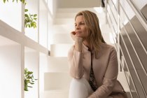 Nachdenkliche Frau entspannt sich zu Hause im Treppenhaus — Stockfoto