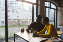 Glückliches Paar benutzt Handy im Café — Stockfoto