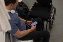 Homem com deficiência usando telefone celular no vestiário — Fotografia de Stock
