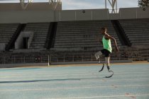 Вид сбоку спортсмена-инвалида, стоящего на беговой дорожке — стоковое фото