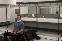 Disabled man listening music on headphones inc hanging room — Stock Photo