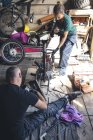 Vue grand angle de la réparation mécanique moto dans le garage — Photo de stock