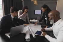Керівники бізнесу обговорюють синій друк в офісі — стокове фото