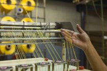 Primer plano del trabajador comprobando el hilo en la máquina en la industria de fabricación de cuerdas - foto de stock