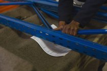 Primer plano del trabajador que arregla el estante de la plataforma en la industria de fabricación de cuerdas - foto de stock
