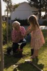 Nonna e nipote piantare in giardino in una giornata di sole — Foto stock