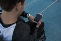 Atleta discapacitado comprobando el tiempo mientras usa la tableta digital en el lugar de deportes - foto de stock