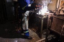 Low section of blacksmith using a welding torch in workshop — Stock Photo