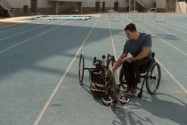 Athlète handicapé masculin avec fauteuil roulant sur une piste de course — Photo de stock