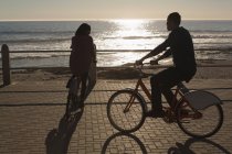 Coppia biciclette a cavallo sul lungomare vicino alla spiaggia — Foto stock