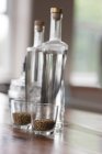 Gros plan sur les bouteilles de brasserie et les grains de blé dans les verres — Photo de stock