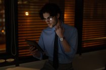 Мужчина руководитель с помощью цифрового планшета в офисе ночью — стоковое фото