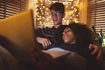 Couple en utilisant un ordinateur portable dans le salon confortable à la maison — Photo de stock