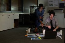 Executivos discutindo sobre laptop no escritório à noite — Fotografia de Stock