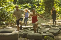 Fit people training over tires obstacle course at boot camp — Stock Photo