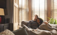 Пара отдыхает под одеялом в гостиной на дому — стоковое фото