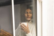 Удумлива жінка має каву вдома — стокове фото