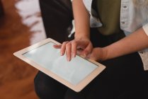 Крупный план женских рук с помощью цифрового планшета в помещении — стоковое фото