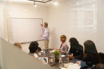 Executivos discutindo sobre quadro branco na sala de conferências no escritório — Fotografia de Stock